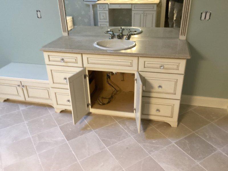 Completed installation of bathroom vanity with integrated sink and chrome fixtures, including proper plumbing connections and drain assembly. Also installed shower stall with fiberglass walls, handheld showerhead system, and grab bar for safety. Reset all plumbing in primary and guest bathrooms as requested, ensuring proper function and no leaks.