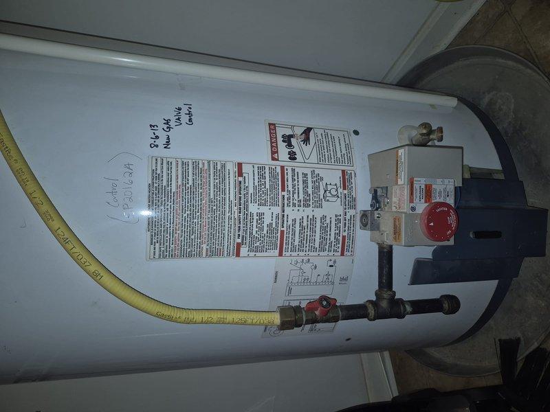 Conducted water heater replacement estimate, documenting existing gas-fired unit with expansion tank. Current installation includes standard residential gas water heater with yellow flexible gas line connection, temperature control unit, and associated copper piping and pressure relief valves. System appears functional but scheduled for replacement per customer request.