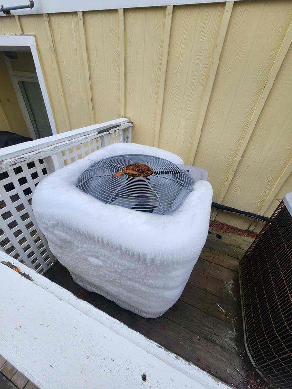 Responded to service call for heat pump with no heat. Found outdoor unit completely encased in ice with defrost cycle failure. Activated emergency heat mode to restore temporary heating while allowing system to defrost. Verified thermostat operation (showing 67°F) and educated customer on proper system operation during recovery period.