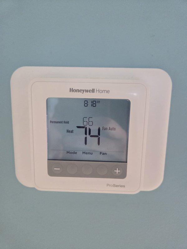 Performed routine heating maintenance on system equipped with Honeywell ProSeries thermostat. Conducted electrical diagnostics using Fieldpiece meter, testing voltage across control board terminals. System operating normally with thermostat properly calibrated and maintaining set temperature parameters.