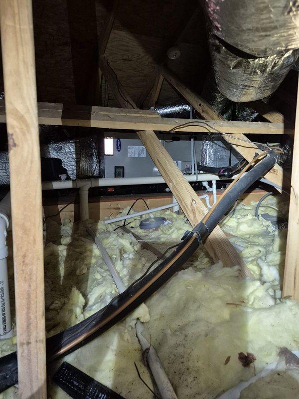 Performed seasonal cooling maintenance on two systems. Inspected crawl space/attic area, noting exposed ductwork with reflective wrapping and compressed fiberglass insulation. Confirmed proper operation of Bryant Evolution Connex thermostat, which was set to heat mode (70°/65°) and functioning normally.