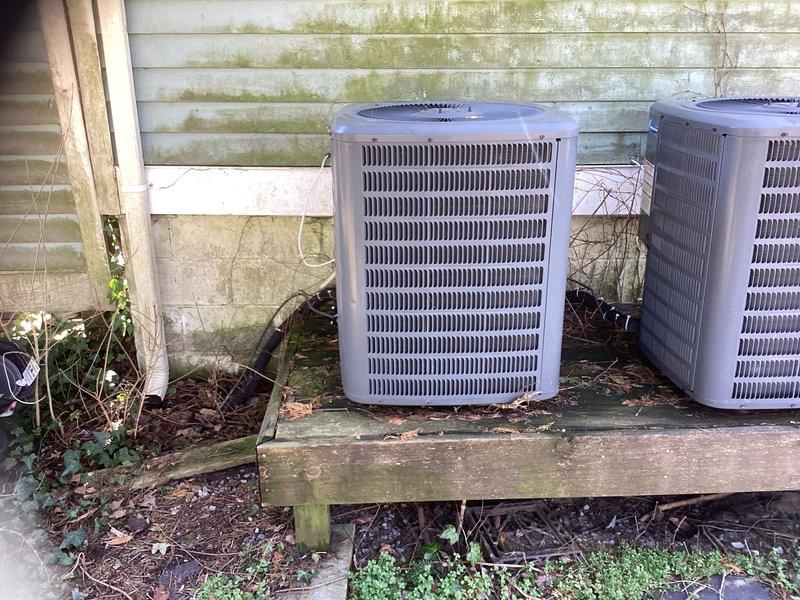 Performed assessment for downstairs HVAC system replacement. Existing outdoor condensers show significant aging with weathered mounting platform and surrounding vegetation encroachment. Interior inspection revealed need for complete refrigerant line replacement as current lines are buried and inaccessible. Recommended full system replacement including new properly installed refrigerant lines and appropriate system sizing for the space.