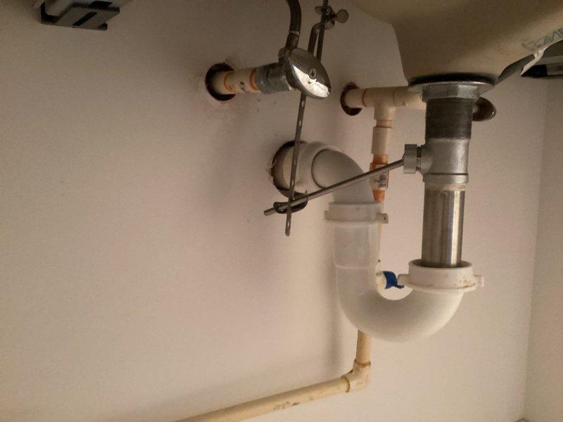 Completed reinstallation of faucet on bathroom vanity following backsplash installation. Properly connected supply lines and verified drainage system functionality with P-trap configuration. Ensured all connections were secure with no leaks upon testing.
