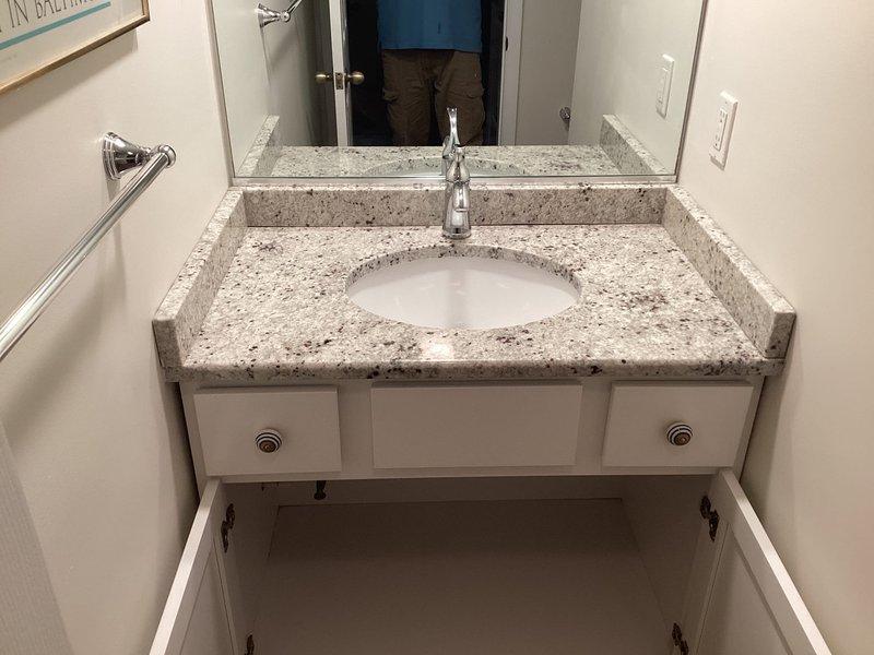 Completed reinstallation of faucet on bathroom vanity following backsplash installation. Properly connected supply lines and verified drainage system functionality with P-trap configuration. Ensured all connections were secure with no leaks upon testing.