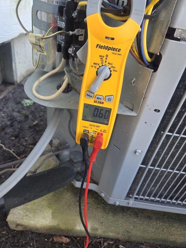 Performed scheduled cooling maintenance visit on residential system. Inspected Honeywell thermostat functionality (displaying 66°F indoor temperature with 62°F heat setpoint) and verified system operation in heat mode. Conducted electrical diagnostics using Fieldpiece SC260 clamp meter, recording 0.60 amp reading on primary components to confirm proper electrical performance.
