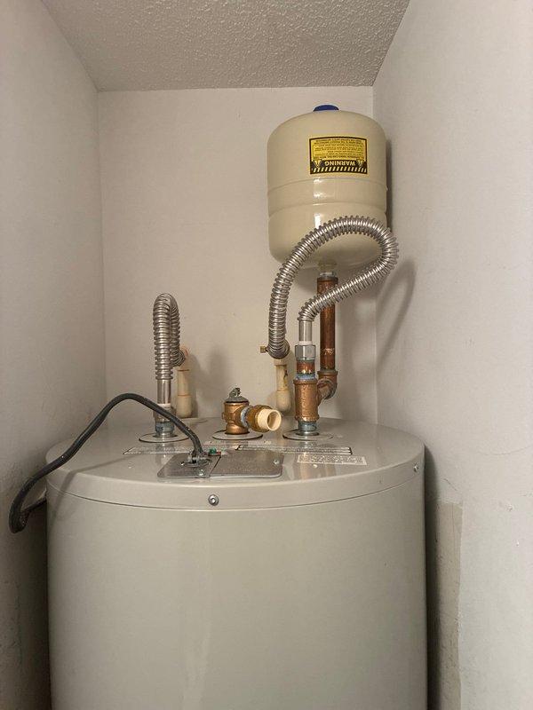 Successfully removed and disposed of old water heating system and installed new Bradford White RE250T6 50-gallon electric water heater with expansion tank. Installation included new 23" x 20 3/4" metal drain pan without drain, brass fittings, and flexible connections. System was properly connected and tested for operation.