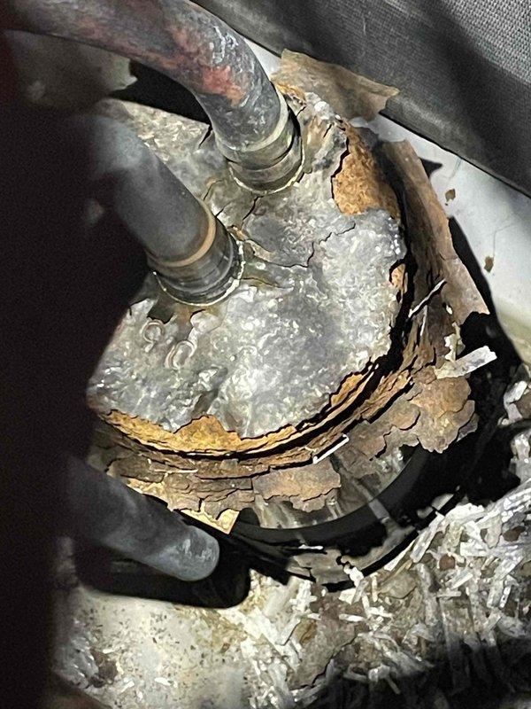 Performed scheduled cooling maintenance on an aging Carrier outdoor condensing unit showing significant weathering, corrosion, and debris accumulation around the base. Inspection revealed severe deterioration of connecting refrigerant lines with extensive insulation damage and pipe corrosion that requires immediate attention to prevent system failure. Documented conditions with photos for reference.
