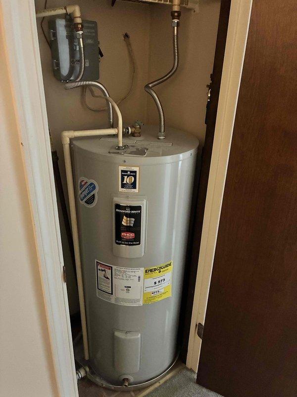 Performed inspection and provided estimate for replacement of existing 40-gallon water heater located in utility closet with limited access (23"W doorway, 20"W x 48"T space). Current unit has standard electrical connections with junction box mounted on wall and copper/flexible metal piping connections at top of heater.