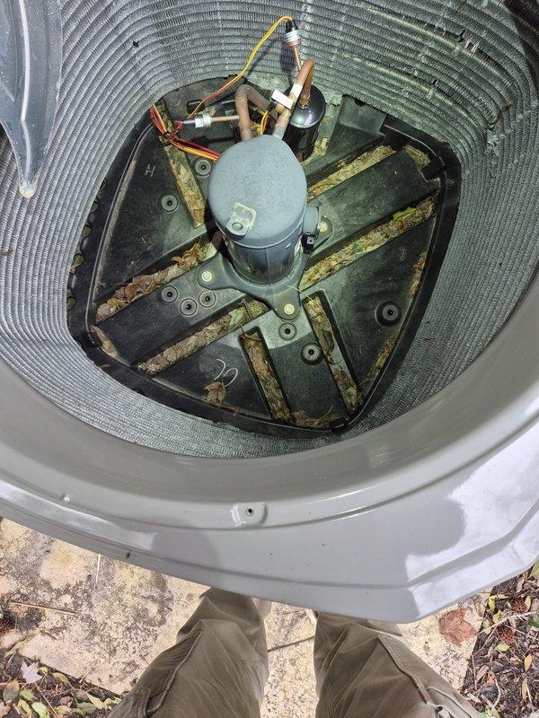 Performed routine cooling maintenance check on residential HVAC system. Conducted electrical diagnostics with multimeter on capacitor showing 732 reading. Observed significant rust/corrosion on compressor base plate and interior components requiring future attention.