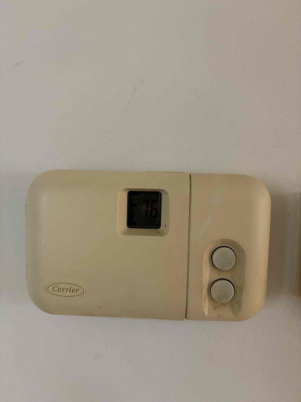 Responded to no heat complaint following recent Preventative Tune Up. Inspected Carrier thermostat showing 76°F display and examined furnace installation with visible connections and control module. Determined thermostat was functioning properly but system was set to cooling mode rather than heating; reset operating mode and verified proper heat operation.