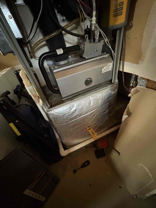 Responded to no heat complaint following recent Preventative Tune Up. Inspected Carrier thermostat showing 76°F display and examined furnace installation with visible connections and control module. Determined thermostat was functioning properly but system was set to cooling mode rather than heating; reset operating mode and verified proper heat operation.