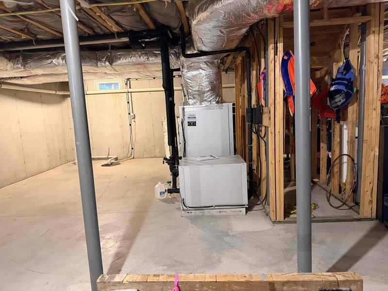 # HVAC Estimate - Replacement Summary

Conducted site evaluation for 17-year-old geothermal system replacement serving upper level of residence. Primary concern identified as leaking indoor coil in basement-mounted geo cube unit, necessitating complete system replacement due to age and condition of equipment.

Assessed existing upstairs air handler installation, originally converted from furnace configuration in 2009. Inspection revealed current system operating on inadequate 14-gauge wiring with 15-amp breaker and no auxiliary heat capability. Documented attic-mounted ductwork distribution system with metallic flexible ducts and existing insulation conditions. Examined basement mechanical room housing white air handler unit with associated refrigerant lines and condensate piping.

Provided comprehensive replacement quote for new geothermal system including indoor coil and air handler. Advised customer that installation of air handler with auxiliary heat kit will require licensed elect