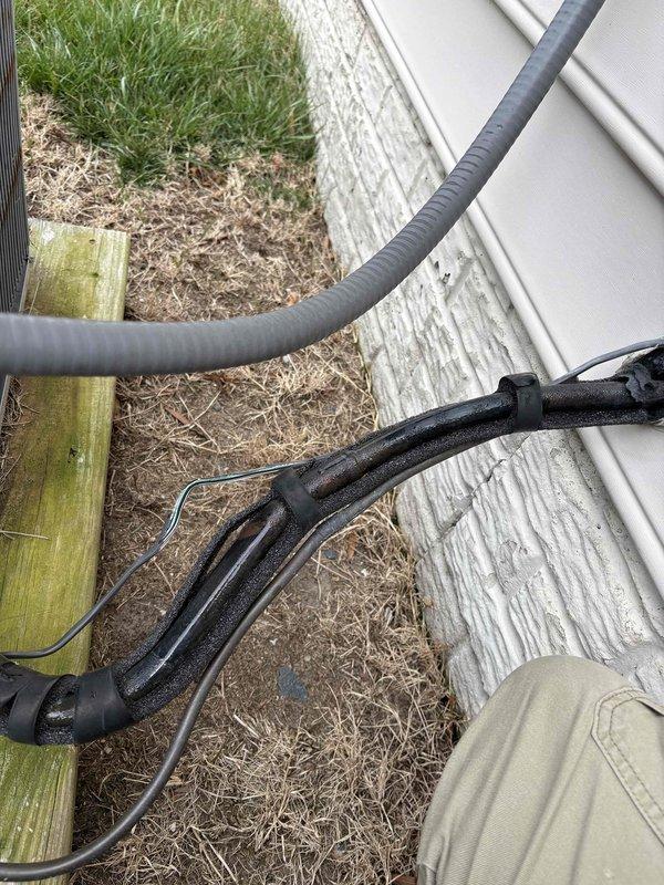 # HVAC Maintenance - Cooling System Service

Responded to service call for cooling system evaluation. Upon arrival, performed comprehensive cool check on residential air conditioning system. Inspected refrigerant line set installation along building exterior, verifying proper insulation integrity and secure mounting of black foam-wrapped lines. Examined indoor components including condensate drain piping configuration in attic space, confirming proper PVC drain line installation and connections. All refrigerant lines showed appropriate insulation coverage with no visible damage or deterioration. Condensate drainage system functioning properly with correct pitch and secure mounting. System operational and cooling effectively at time of inspection.