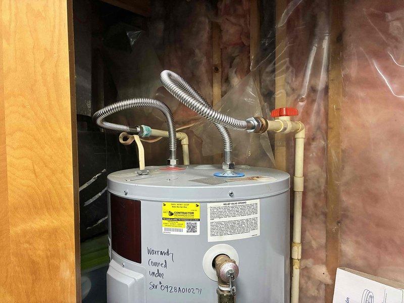 Responded to service call for electric tanked water heater leaking from lower access panel in mechanical room. Upon inspection, identified active leak originating from bottom heating element or drain valve area. Replaced defective water heater unit with new electric tanked model, including installation of expansion tank, connection of copper supply lines, and flexible metallic conduits for electrical service. Tested all connections for proper operation and verified no leaks present upon completion.