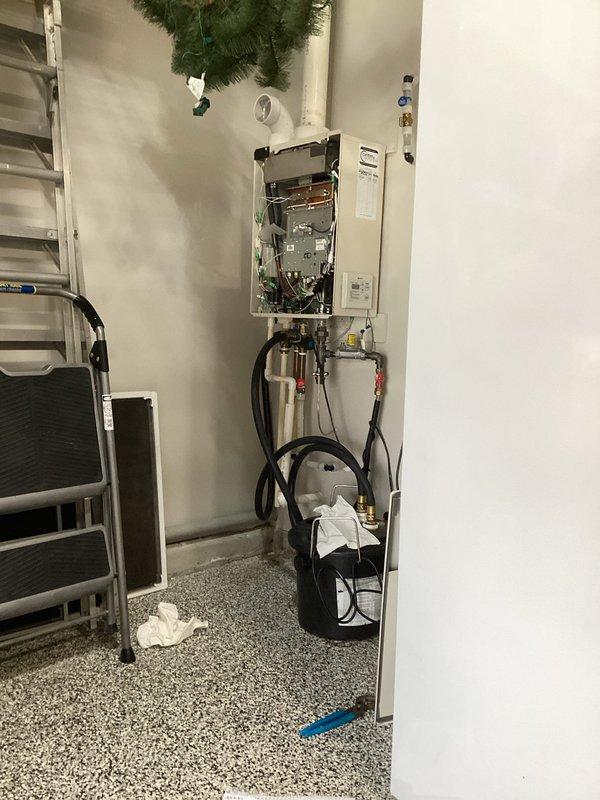 Performed routine maintenance inspection on wall-mounted tankless water heater unit. Accessed internal components by opening front service panel and conducted thorough examination of burners, heat exchangers, electronic controls, and electrical connections. Inspected gas supply connections including regulator and pressure valve, verified integrity of copper piping, brass fittings, and flexible supply lines, and confirmed all shut-off valves were functioning properly. Unit operating within normal parameters with no issues identified.