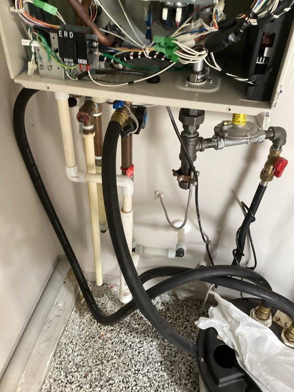 Performed routine maintenance inspection on wall-mounted tankless water heater unit. Accessed internal components by opening front service panel and conducted thorough examination of burners, heat exchangers, electronic controls, and electrical connections. Inspected gas supply connections including regulator and pressure valve, verified integrity of copper piping, brass fittings, and flexible supply lines, and confirmed all shut-off valves were functioning properly. Unit operating within normal parameters with no issues identified.