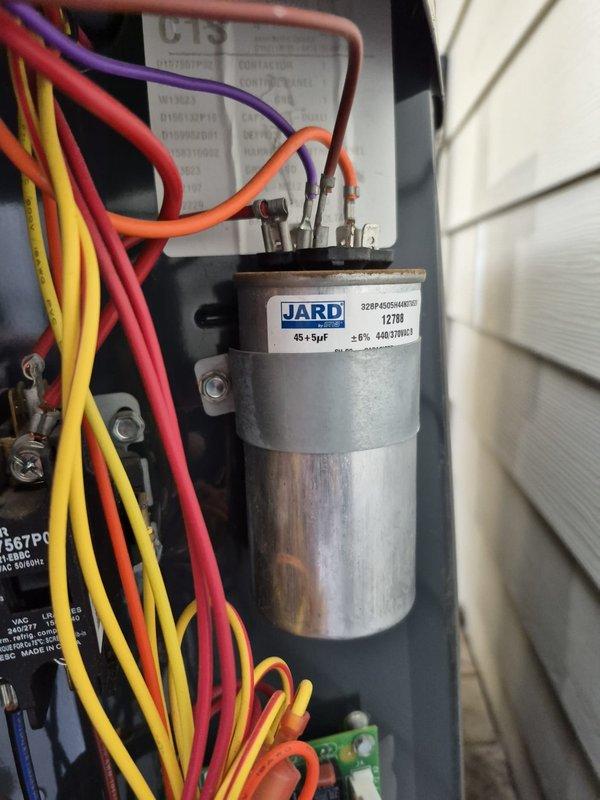 Completed scheduled cooling maintenance visit on residential HVAC system. Performed comprehensive inspection of outdoor condensing unit, including electrical panel assessment and capacitor evaluation. Verified JARD dual-run capacitor (45+5µF) operational status and electrical connections across all terminals. Conducted voltage and amperage readings using digital multimeter, confirming system operating within normal parameters at 6.15V reading. Inspected all wire connections including red, purple, orange, yellow, blue, and black conductors for secure terminations and proper routing. All electrical components, control wiring, and capacitor mounting hardware found in functional condition with age-appropriate wear. System tested and confirmed operational for cooling season.