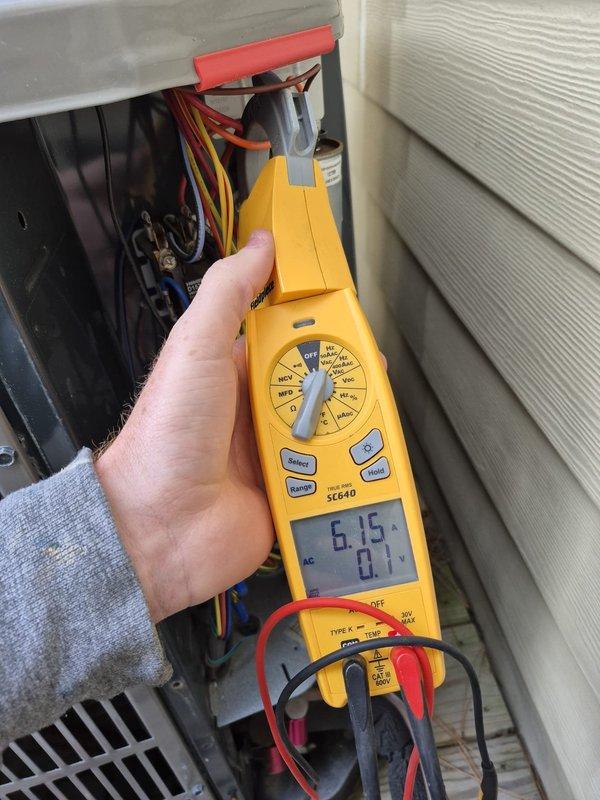 Completed scheduled cooling maintenance visit on residential HVAC system. Performed comprehensive inspection of outdoor condensing unit, including electrical panel assessment and capacitor evaluation. Verified JARD dual-run capacitor (45+5µF) operational status and electrical connections across all terminals. Conducted voltage and amperage readings using digital multimeter, confirming system operating within normal parameters at 6.15V reading. Inspected all wire connections including red, purple, orange, yellow, blue, and black conductors for secure terminations and proper routing. All electrical components, control wiring, and capacitor mounting hardware found in functional condition with age-appropriate wear. System tested and confirmed operational for cooling season.