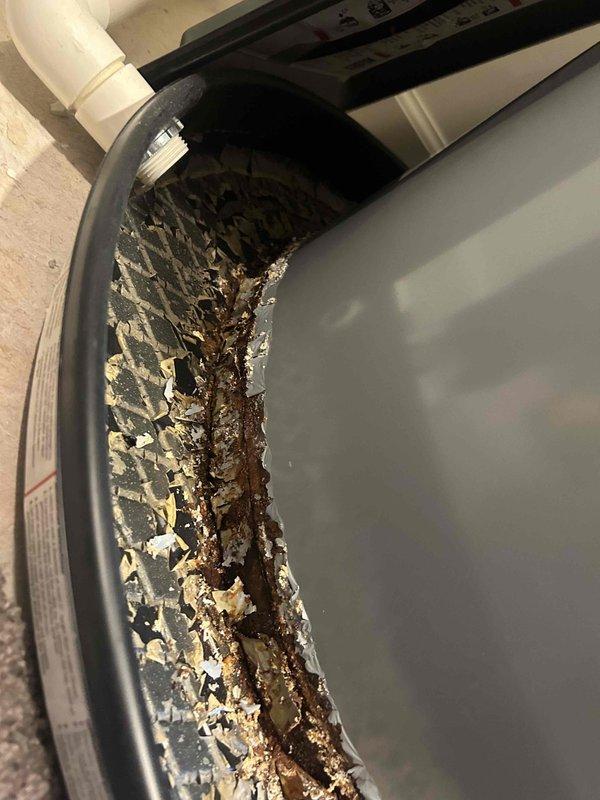 Replaced customer-supplied Goodman drain pan on HVAC air handler unit due to severe corrosion and deterioration caused by long-term water damage. Extensive rust and mineral deposits were evident throughout the base and interior walls of the original pan, with moisture damage extending to surrounding areas. Installation required approximately 3-4 hours and included proper fitting of 2" PVC couplings for drainage system connections, with warranty documentation completed for component removal and replacement.