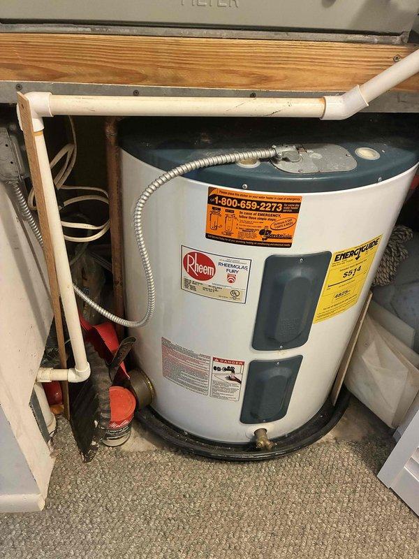 Performed on-site evaluation of 50-gallon electric water heater located in utility closet and assessed hall toilet reported to be leaking. Inspected existing water heater installation, noting age-related deterioration including mineral deposits and water staining on tank top, patina on copper supply lines, and overall condition of plumbing connections including brass fittings, shut-off valves, and temperature/pressure relief valve assembly. Documented current Rheem unit configuration with copper and PEX supply piping in confined space installation. Evaluated hall toilet for reported leak condition. Provided estimates for complete replacement of water heater unit and toilet fixture as requested by HOA requirements.