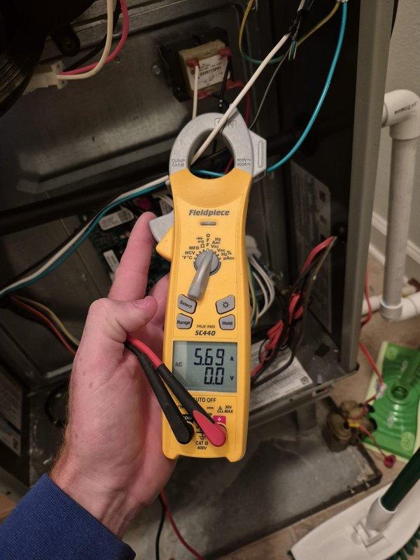 Performed cooling system tune-up and diagnostic evaluation on HVAC unit. Utilized clamp meter to measure electrical readings, recording 5.69 amps at indoor unit and 122.5 volts with 0.16 amps at outdoor condenser unit. Inspected electrical connections, control board, wiring, and all system components to verify proper operation and complete scheduled maintenance check.