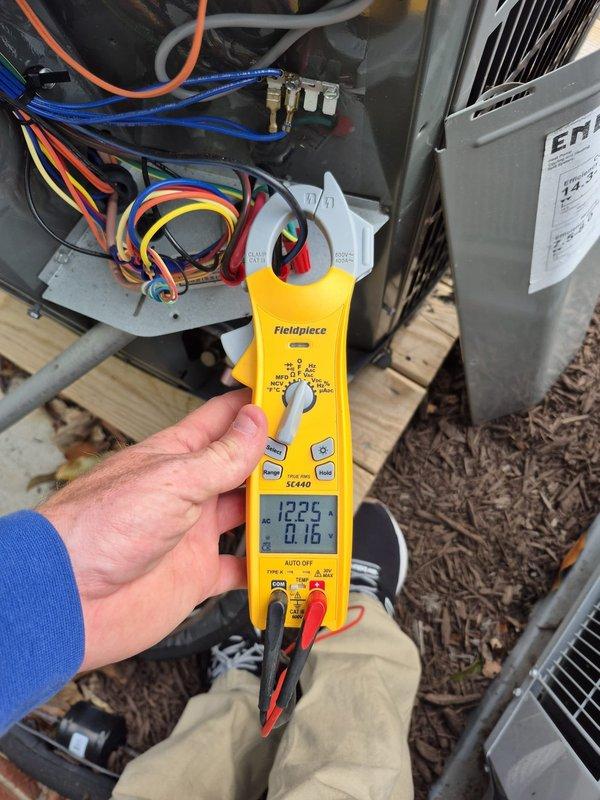 Performed cooling system tune-up and diagnostic evaluation on HVAC unit. Utilized clamp meter to measure electrical readings, recording 5.69 amps at indoor unit and 122.5 volts with 0.16 amps at outdoor condenser unit. Inspected electrical connections, control board, wiring, and all system components to verify proper operation and complete scheduled maintenance check.
