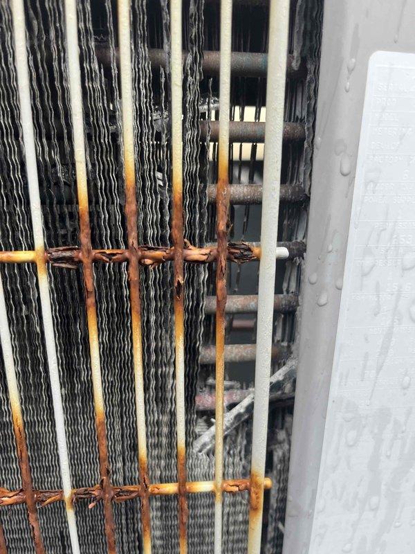 # HVAC Maintenance - Cooling System Service

Completed comprehensive cooling system maintenance inspection and preventive service on residential HVAC unit. Performed thorough visual assessment of outdoor condenser unit, identifying moderate to heavy rust and corrosion present on condenser coil support brackets and mounting hardware. Condenser fins showed typical wear pattern with black and white striping visible through accumulated oxidation on horizontal supports. 

Conducted standard Cool Check maintenance protocol including inspection of all major system components. Verified refrigerant charge and system pressures within manufacturer specifications. Inspected electrical connections, contactors, and capacitor operation. Cleaned condenser coil surfaces to improve heat transfer efficiency despite corrosion present on structural supports. 

Assessed indoor equipment installation in utility closet, confirming proper clearances and ventilation. Verified thermostat operation and system cyc