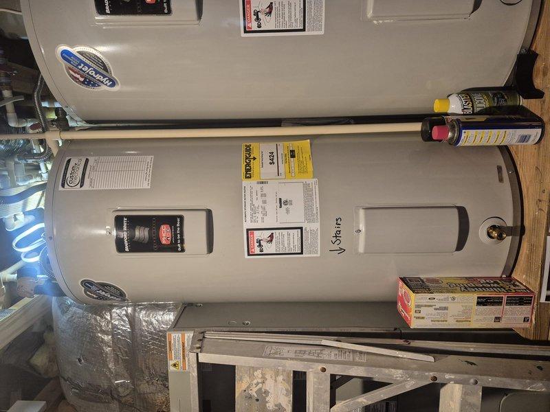 Responded to service call for reported leak on top of residential tanked water heater. Upon arrival, inspected dual water heater installation in basement utility area. Located source of leak at top connections of one unit. Assessed plumbing connections, temperature and pressure relief valve, and inlet/outlet piping for signs of active water seepage. Documented condition of both water heaters and surrounding plumbing components through photographic evidence. Tightened loose fitting connections and verified proper sealing of all top-mounted components. Tested system operation and monitored for continued leakage to confirm repair effectiveness.