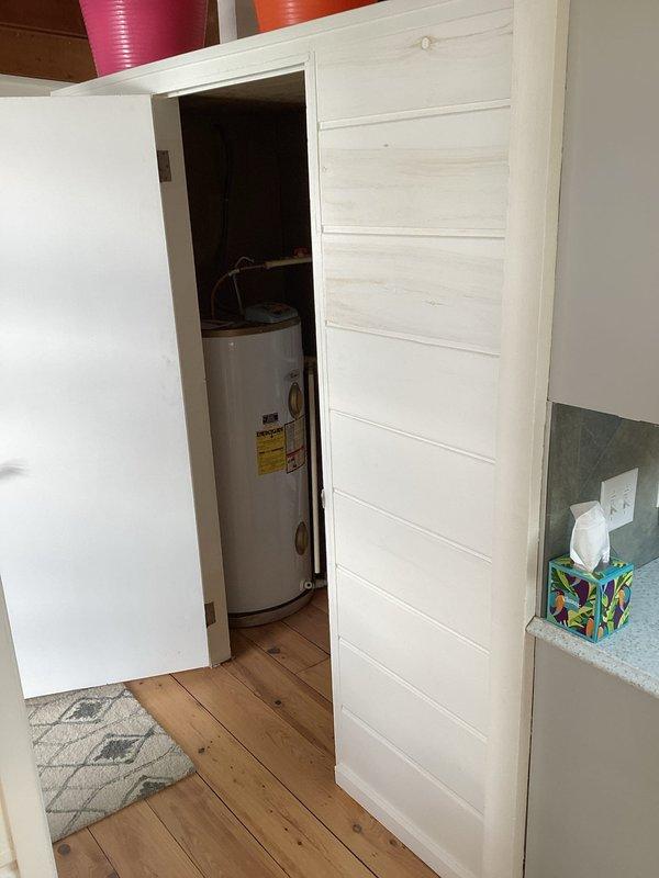 Responded to no hot water complaint for 50-gallon electric water heater located in closet behind kitchen serving front half of residence. Upon inspection, confirmed unit was inoperative with no indicator light illuminated. Identified water heater as AO Smith model EE3J50RD045V manufactured in 1999, which had reached end of serviceable life after 27 years of operation. Documented existing installation conditions including copper supply piping connections and electrical configuration. Provided estimate for replacement of failed electric water heater unit with new equipment to restore hot water service to kitchen and front portion of home.