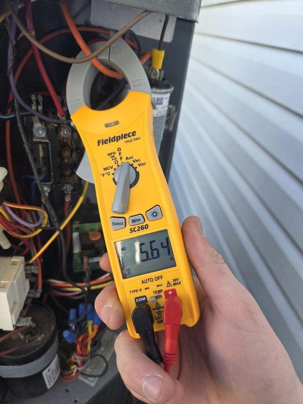 Performed comprehensive cooling system maintenance and diagnostics on HVAC unit. Accessed equipment in attic space using provided entry code and conducted electrical measurements, recording compressor amperage draw of 66.4 amps and total runtime of 37.5 hours on diagnostic meter. Inspected condensate drain system including PVC elbow fittings, verified proper drainage function, and examined ductwork insulation integrity throughout mechanical space. All electrical connections, capacitor, and control board components tested and found operating within normal parameters.