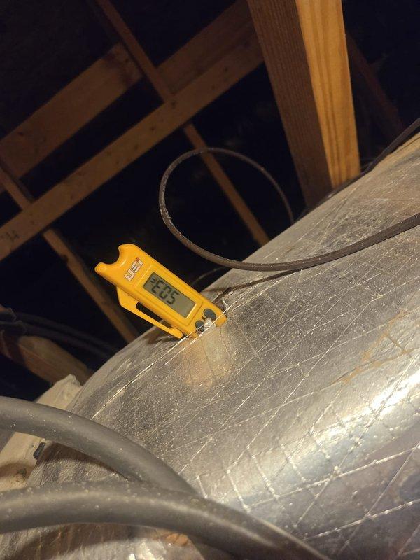 Performed routine cooling system maintenance on outdoor heat pump unit and verified electrical connections. Measured voltage at control board terminal block, recording 12.1V reading to confirm proper low-voltage power supply to unit controls. Inspected attic ductwork and recorded supply air temperature of 83.5°F at main trunk line. All electrical connections secure, unit operational, and system cooling properly.