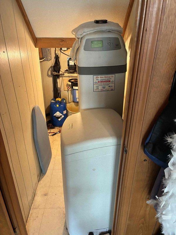 Responded to no hot water complaint on electric water heater. Upon arrival, verified lack of hot water at fixtures and checked electrical panel for tripped breakers. Inspected water heater installation in utility closet, confirmed power supply to unit, and assessed overall plumbing system including water softener and filtration equipment. Photographed equipment configuration and mechanical room setup for service documentation.