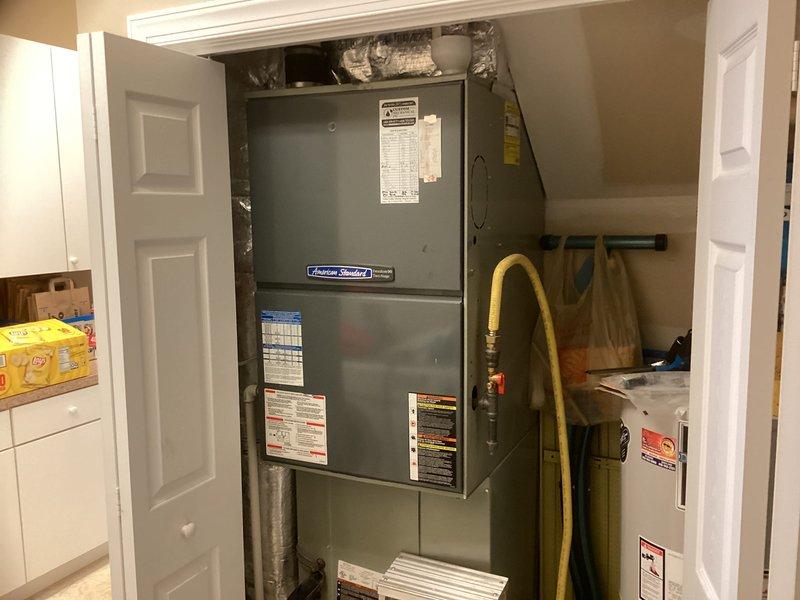 Conducted site evaluation for outdoor unit replacement on dual-zone residential HVAC system. Inspected two existing outdoor condensing units from 2008 installation showing weathered condition but currently operational. Documented existing equipment configuration including attic-mounted air handler with refrigerant lines and condensate drainage, and closet-mounted American Standard air handler with associated ductwork. Photographed current system components to provide accurate replacement estimate for outdoor units while retaining functional indoor equipment.