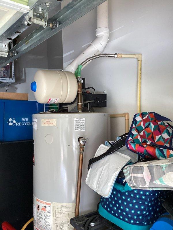 Responded to service call for gas water heater with reported slow leak in garage. Upon inspection, evaluated 48-gallon Bradford White LP gas water heater with expansion tank installed. Assessed unit condition, examined copper supply piping connections, flexible connector, and PVC venting system for leak source. Documented equipment specifications including 65,000 BTU/hr input rating and current operational status. Photographed water heater installation, labeling, and surrounding plumbing configuration. Provided estimate for tank-style gas water heater replacement options to address leak issue.