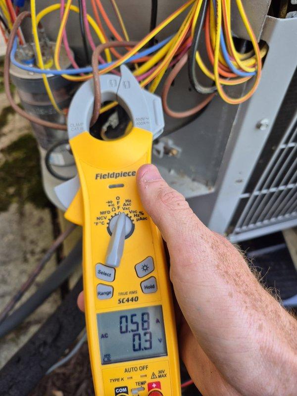 Completed scheduled cooling maintenance visit on residential HVAC system. Performed electrical diagnostics using clamp meter to verify proper amperage draw and system operation at outdoor condensing unit. Measured current readings on compressor circuit and confirmed electrical connections at capacitor terminals were secure and within manufacturer specifications. Verified thermostat operation and settings, noting system currently in heating mode with temperature set to 74°F and fan set to auto operation. All electrical components functioning properly with no deficiencies noted during inspection.