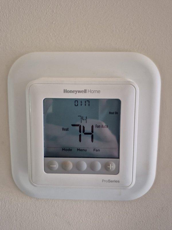Completed scheduled cooling maintenance visit on residential HVAC system. Performed electrical diagnostics using clamp meter to verify proper amperage draw and system operation at outdoor condensing unit. Measured current readings on compressor circuit and confirmed electrical connections at capacitor terminals were secure and within manufacturer specifications. Verified thermostat operation and settings, noting system currently in heating mode with temperature set to 74°F and fan set to auto operation. All electrical components functioning properly with no deficiencies noted during inspection.