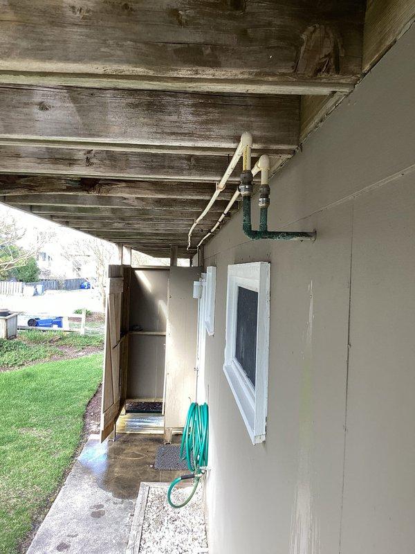 Responded to recurring winter pipe burst issue at outdoor shower location. Replaced failed piping system with copper pipe installation to prevent future freeze damage. New copper distribution system includes multiple branch lines with isolation valves, pressure regulation components, and proper mounting hardware secured to interior wall structure, while exterior connections feature upgraded PVC configuration with winterization capabilities.