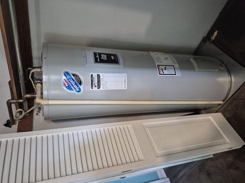 Responded to service call for water heater inspection. Upon arrival, assessed horizontally-mounted white cylindrical tanked water heater installed in interior utility closet. Inspected unit's copper supply line connections, inlet/outlet fittings, and valve assemblies for proper operation and potential leaks. Documented installation configuration and measurements for service records, noting 10-foot clearance specifications. Verified manufacturer labels and safety warnings were visible and intact. Photographed equipment condition and installation setup for documentation purposes. Unit inspection completed with all components accessible and properly configured.