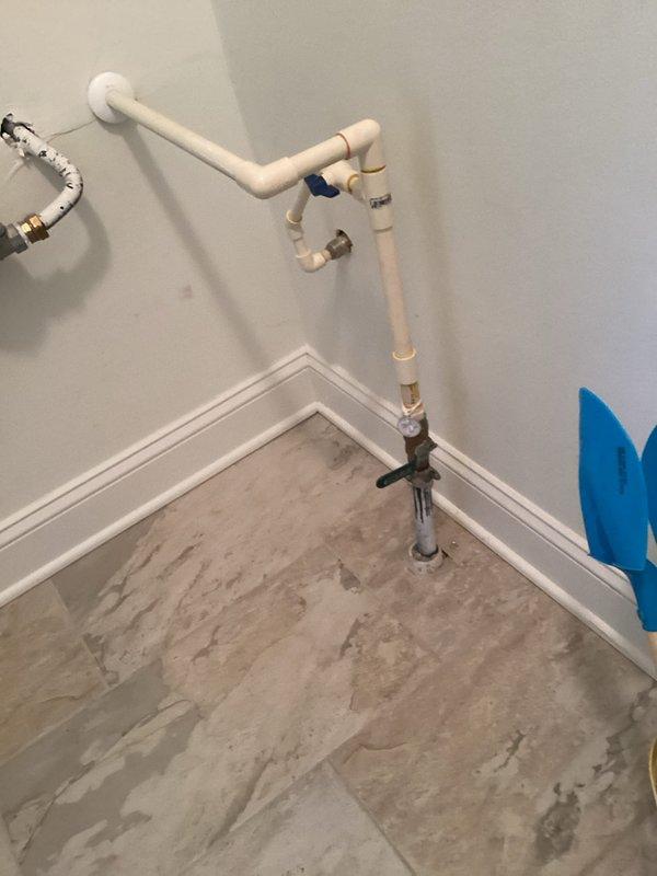 Responded to warranty callback for leaking hose bib on left side of building exterior that was recently installed. Upon inspection, identified leak at the outdoor spigot connection point. Accessed interior plumbing through utility room to diagnose source of water intrusion, which had caused visible moisture damage to vinyl plank flooring. Repaired faulty connection at the hose bib assembly, tested system for proper operation and verified no additional leaks present. Confirmed outdoor spigot now functioning correctly with green garden hose attached and no water discharge at mounting point or interior connections.
