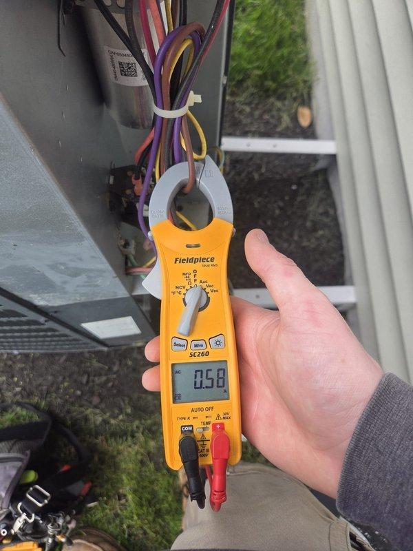 Completed routine cooling maintenance visit on HVAC system. Performed electrical diagnostics using clamp meter, recording amperage readings of 339A and 0.58A on various circuits to verify proper system operation and component function. Inspected electrical connections, wiring bundles, and condensate pump assembly. All measurements within normal operating parameters, system operating as designed.