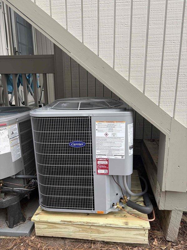 Completed full HVAC system replacement including removal and disposal of existing equipment. Installed Carrier 27SCA524A003 2-ton 15 SEER heat pump on pressure-treated wood platform beneath deck structure, Carrier FJ5ANXB24L00 air handler with Carrier FF2601C10 10kw electric heat pack, and Honeywell TH6320WF digital WiFi thermostat. Fabricated and installed metal duct transitions to adapt new equipment to existing ductwork. Replaced outdoor electrical disconnect and whip while reusing existing condensation lines and primary electrical connections. Verified system performance using refrigerant manifold gauges, confirming proper superheat (17°F), subcooling (323°F suction temperature), and operating pressures (254 PSIG low side, 343 PSIG high side). System commissioned and tested successfully with one-year parts and labor warranty provided from installation date.