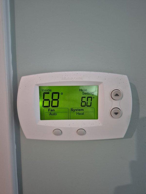 Completed cooling system maintenance check on two HVAC units. Verified thermostat operation showing system in heating mode with proper temperature readings and confirmed electrical measurements on equipment using clamp meter, with amperage readings within normal operating parameters.