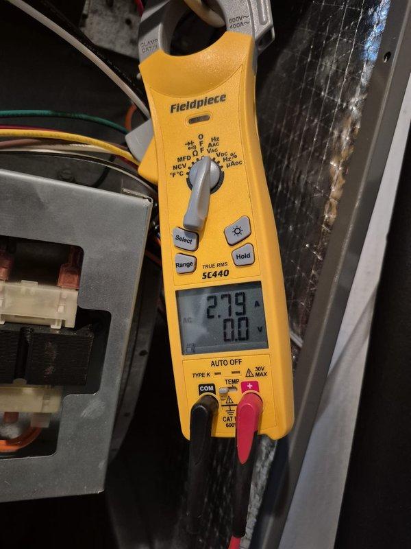 Completed cooling system maintenance check on two HVAC units. Verified thermostat operation showing system in heating mode with proper temperature readings and confirmed electrical measurements on equipment using clamp meter, with amperage readings within normal operating parameters.