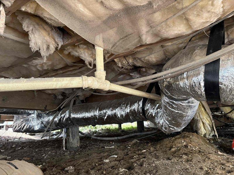 Completed full ductwork system replacement in crawlspace. Removed and disposed of deteriorated fiberglass trunk duct and damaged flexible run outs that showed significant wear and compromised insulation integrity. Installed new insulated metal trunk duct system with flexible run outs throughout crawlspace, incorporating balancing dampers at strategic locations to optimize airflow distribution. Sealed all duct connections with mastic and hard cast tape to ensure proper air sealing and system efficiency. Reused existing floor boots and registers in good condition. All ductwork properly secured to floor joists with appropriate hangers and strapping to prevent sagging and maintain proper pitch for condensate drainage.
