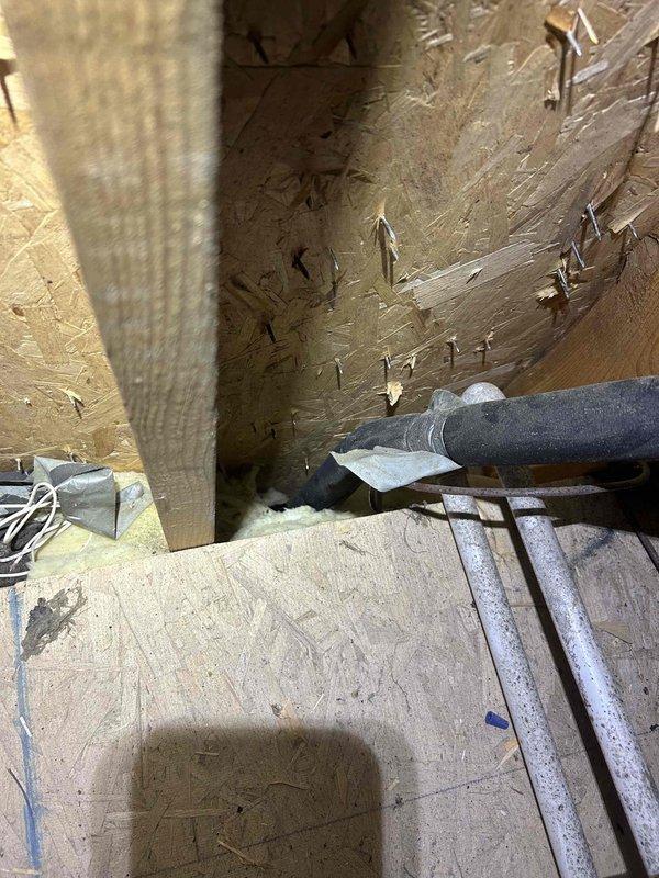 Responded to no-cool service call on residential HVAC system in unfinished construction space. Upon arrival, performed diagnostic inspection of system components including ductwork, refrigerant lines, and electrical connections. Customer suspected failed capacitor, however thorough evaluation of unit required accessing equipment in area with exposed framing and OSB subflooring. Documented system configuration with photos showing flexible ductwork installation and insulated refrigerant line routing through construction space. Completed necessary repairs to restore cooling operation.