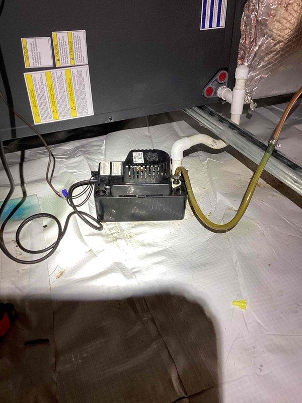 Responded to no cooling complaint on residential HVAC system. Upon arrival, inspected air handler unit located in attic space and verified condensate drainage system components including safety float switch, condensate pump, and PVC drain lines were functioning properly. Documented equipment dimensions and installation configuration for service records. System restored to normal cooling operation.