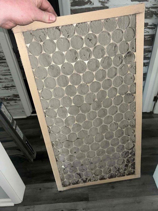 Responded to no cooling complaint at rental property. Upon arrival, performed system diagnostics and discovered severely clogged air filter restricting airflow to the system. Filter was completely saturated with dust and debris, preventing adequate air circulation through the evaporator coil. Replaced dirty filter with new filter, restored proper airflow to the unit. System tested and confirmed cooling operation restored to normal parameters.