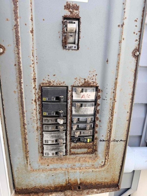 Conducted estimate for HVAC system replacement at townhouse property with 2014 Carrier condensing unit experiencing reduced efficiency. Documented existing outdoor condenser unit in clean condition with proper installation on wooden platform base, though system performance has declined over time. Evaluated electrical disconnect panel showing significant rust corrosion on mounting surface and breaker enclosures, with visible deterioration around circuit breakers including A/C circuit, indicating potential electrical concerns requiring attention during replacement. Provided comprehensive assessment and replacement options to restore system efficiency and address aging equipment concerns.
