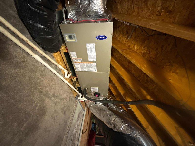 Completed full HVAC system replacement including installation of Carrier 27SCA536A003 3-ton 15 SEER heat pump, Carrier FT5ANBC36L00 variable speed air handler with 10kW electric heat pack, and Honeywell S1200 thermostat in black. Removed and disposed of existing equipment, with outdoor unit temporarily removed to allow contractor access for stand repair before final placement. Installed new outdoor disconnect and electrical whip, reused existing condensation and power lines, and fabricated metal duct transitions to adapt to existing ductwork. Rerouted flex duct line to improve airflow distribution to bedroom while maintaining system efficiency, positioned outdoor unit on repaired stand with proper clearance, and verified all electrical connections and refrigerant lines for proper operation.