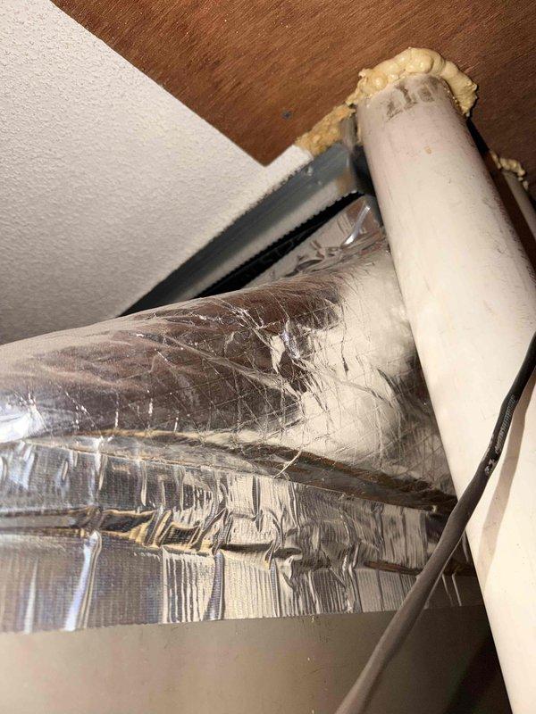 Conducted site visit to front portion of residential property to assess existing HVAC system for replacement estimate. Inspected and documented ductwork components in ceiling cavity, including insulated refrigerant lines with metallic wrap showing wear, flexible duct connections, and foam insulation at penetration points. Evaluated electrical circuit breaker panel capacity and available circuits to determine compatibility with new HVAC equipment installation requirements.